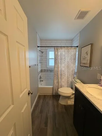a bathroom with a granite countertop toilet a sink and a bathtub