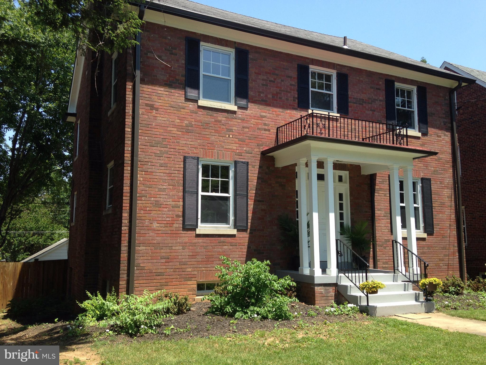 front view of a brick house with a yard