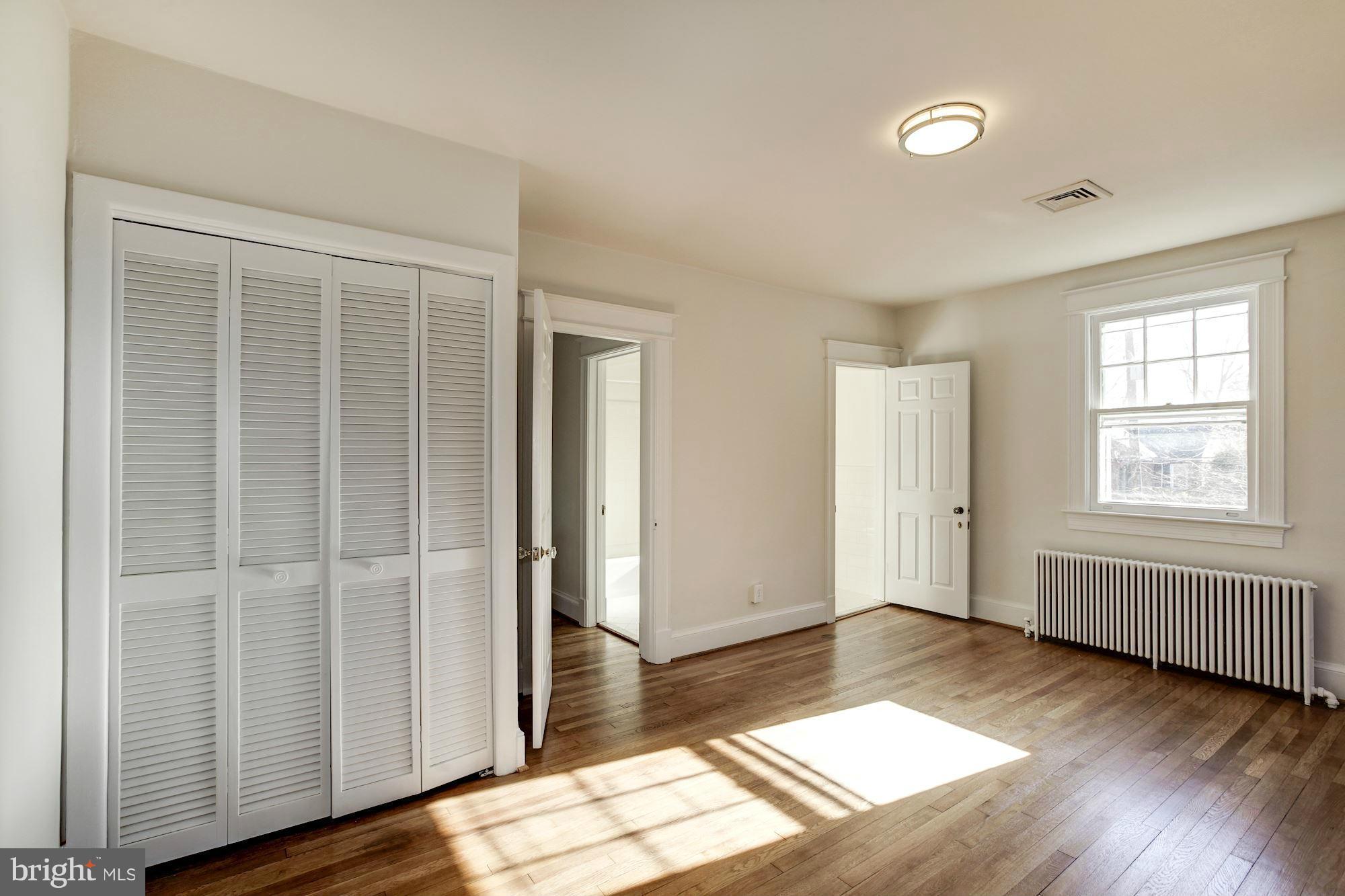 3111 Rittenhouse Street Northwest Washington, DC 20015 - Photo 14 of 30 an empty room with wooden floor and windows