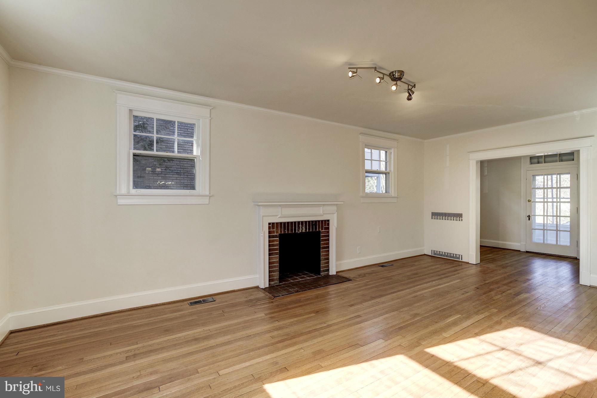 3111 Rittenhouse Street Northwest Washington, DC 20015 - Photo 5 of 30 an empty room with wooden floor fireplace and windows