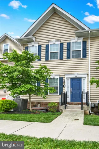 a view of a house with a yard and potted plants
