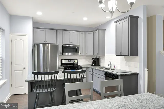 a kitchen with stainless steel appliances a stove a sink refrigerator and a microwave