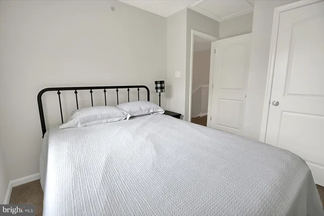 a large bed in a bedroom with a white comforter and pillows