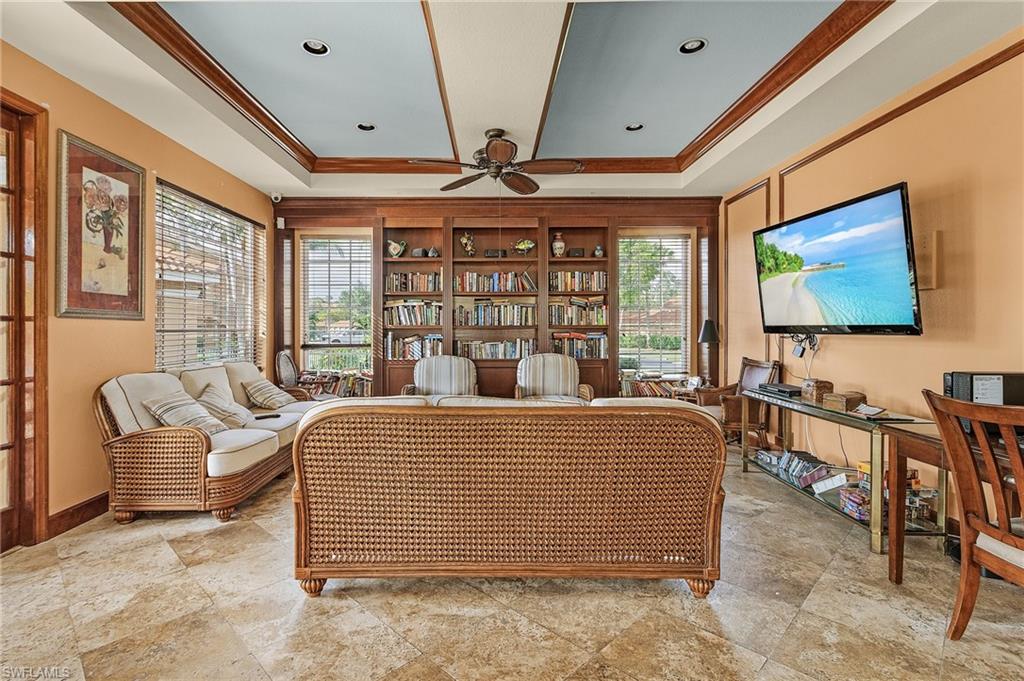 1180 Wildwood Lakes Boulevard, Unit 208 Naples, FL 34104 - Photo 12 of 19 a living room with furniture a flat screen tv and large window
