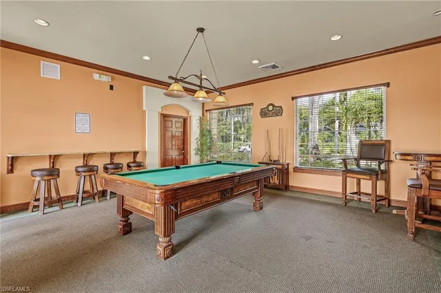 a room with pool table and windows