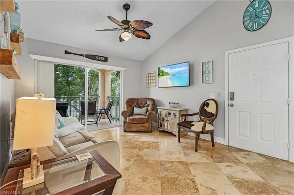 a living room with furniture a flat screen tv and a window