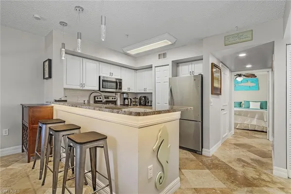 a kitchen with stainless steel appliances a refrigerator stove microwave and white cabinets