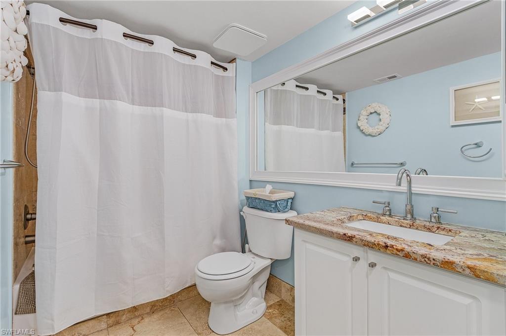 1180 Wildwood Lakes Boulevard, Unit 208 Naples, FL 34104 - Photo 6 of 19 a bathroom with a granite countertop sink toilet and a mirror