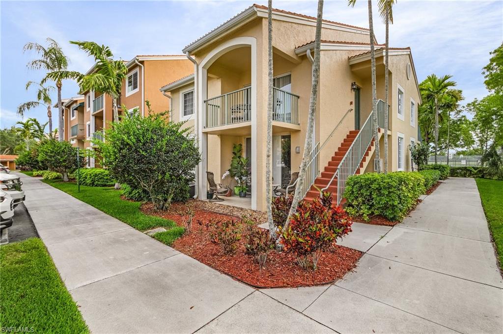 1180 Wildwood Lakes Boulevard, Unit 208 Naples, FL 34104 - Photo 10 of 19 a front view of a residential apartment building with a yard