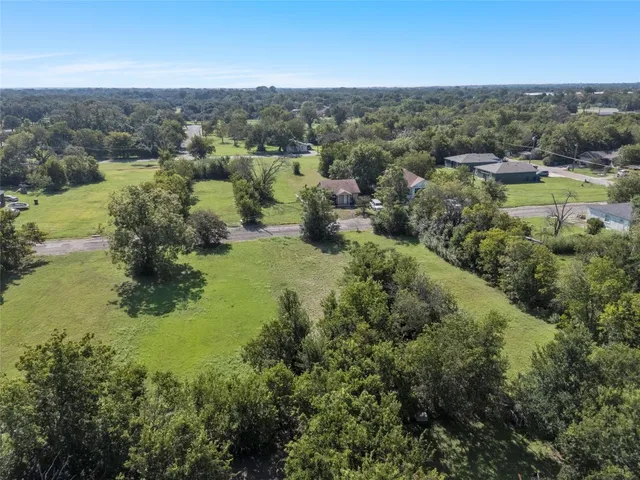 an aerial view of residential houses with outdoor space and trees