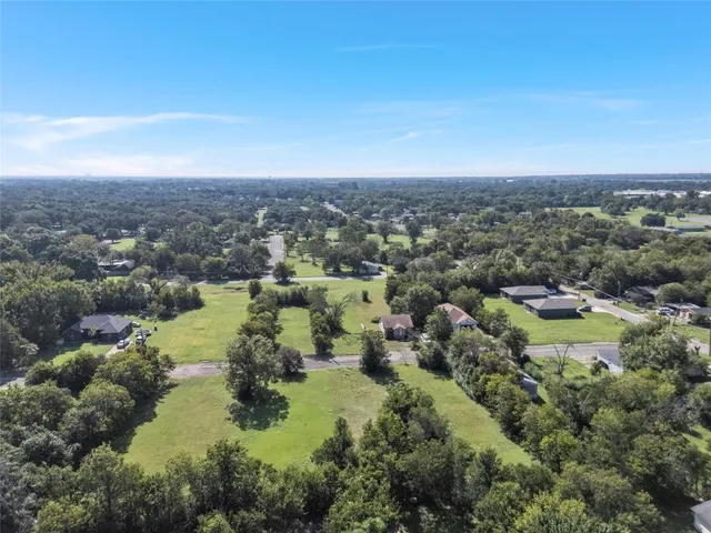 an aerial view of residential house with outdoor space and trees all around