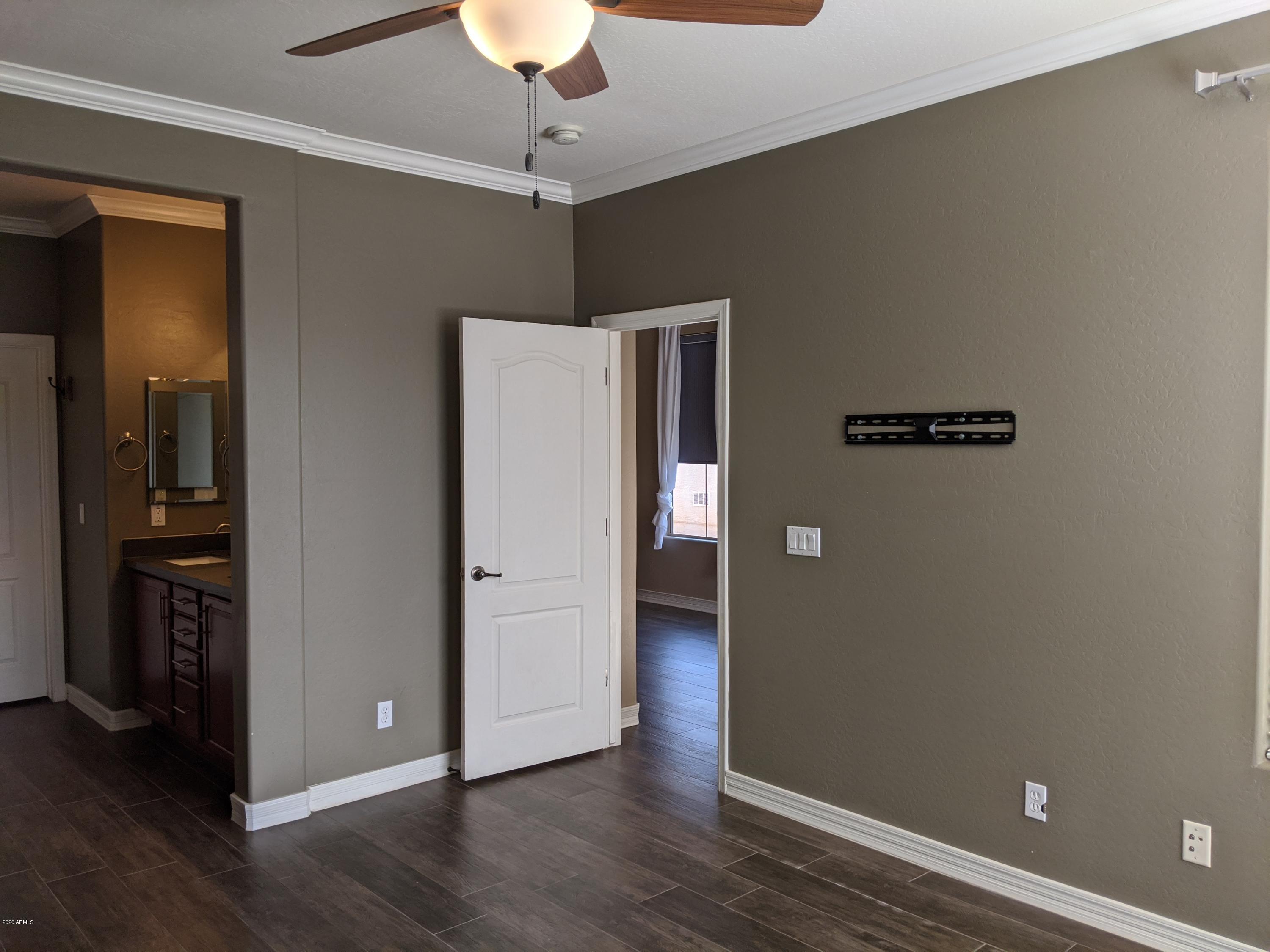 21019 East Avenida Del Valle Queen Creek, AZ 85142 - Photo 12 of 52 a view of an empty room with wooden floor and a ceiling fan