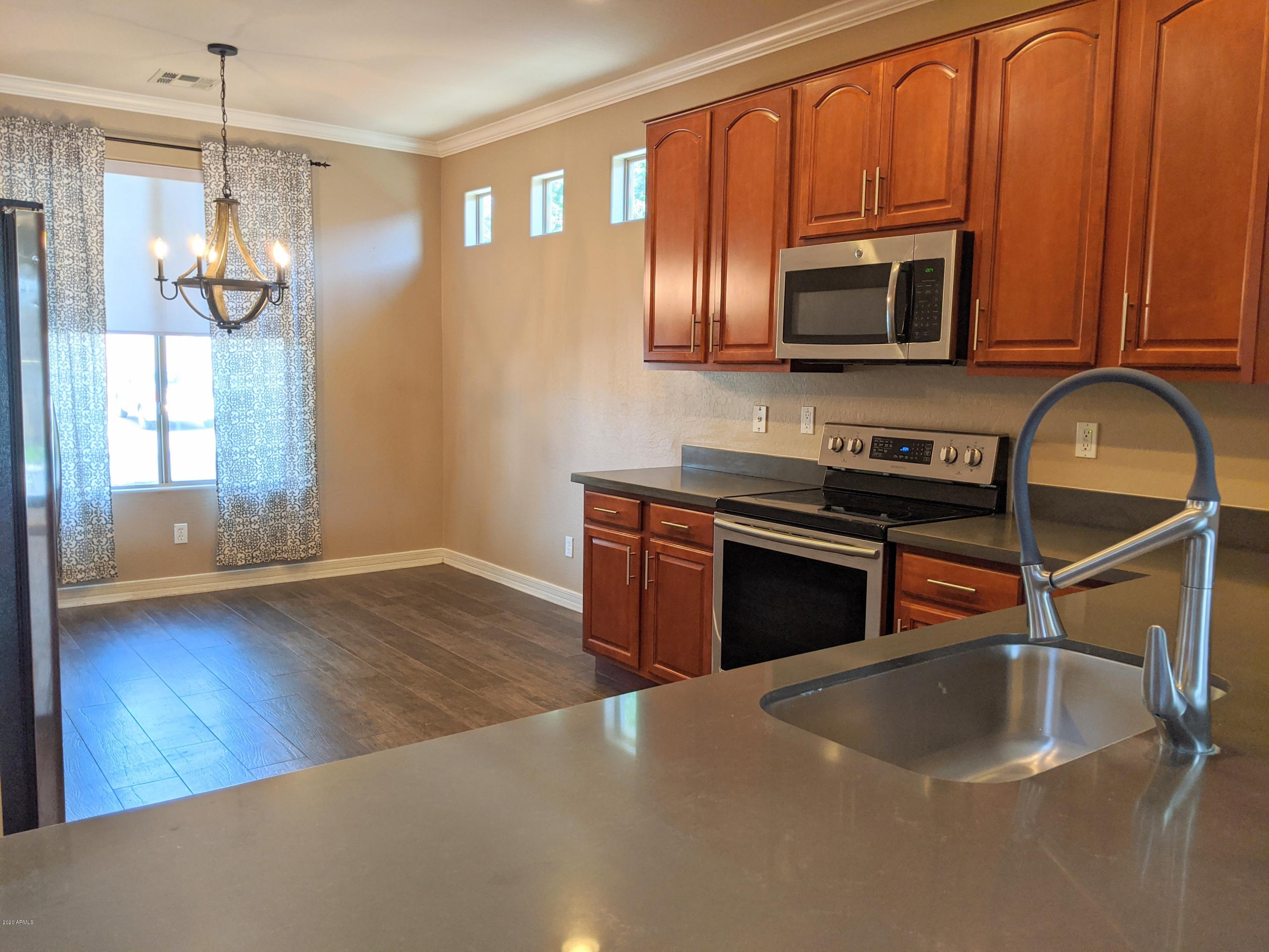 21019 East Avenida Del Valle Queen Creek, AZ 85142 - Photo 19 of 52 a kitchen with stainless steel appliances granite countertop a stove a microwave and a refrigerator