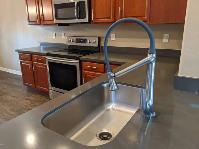 a kitchen with stainless steel appliances granite countertop a stove microwave and sink