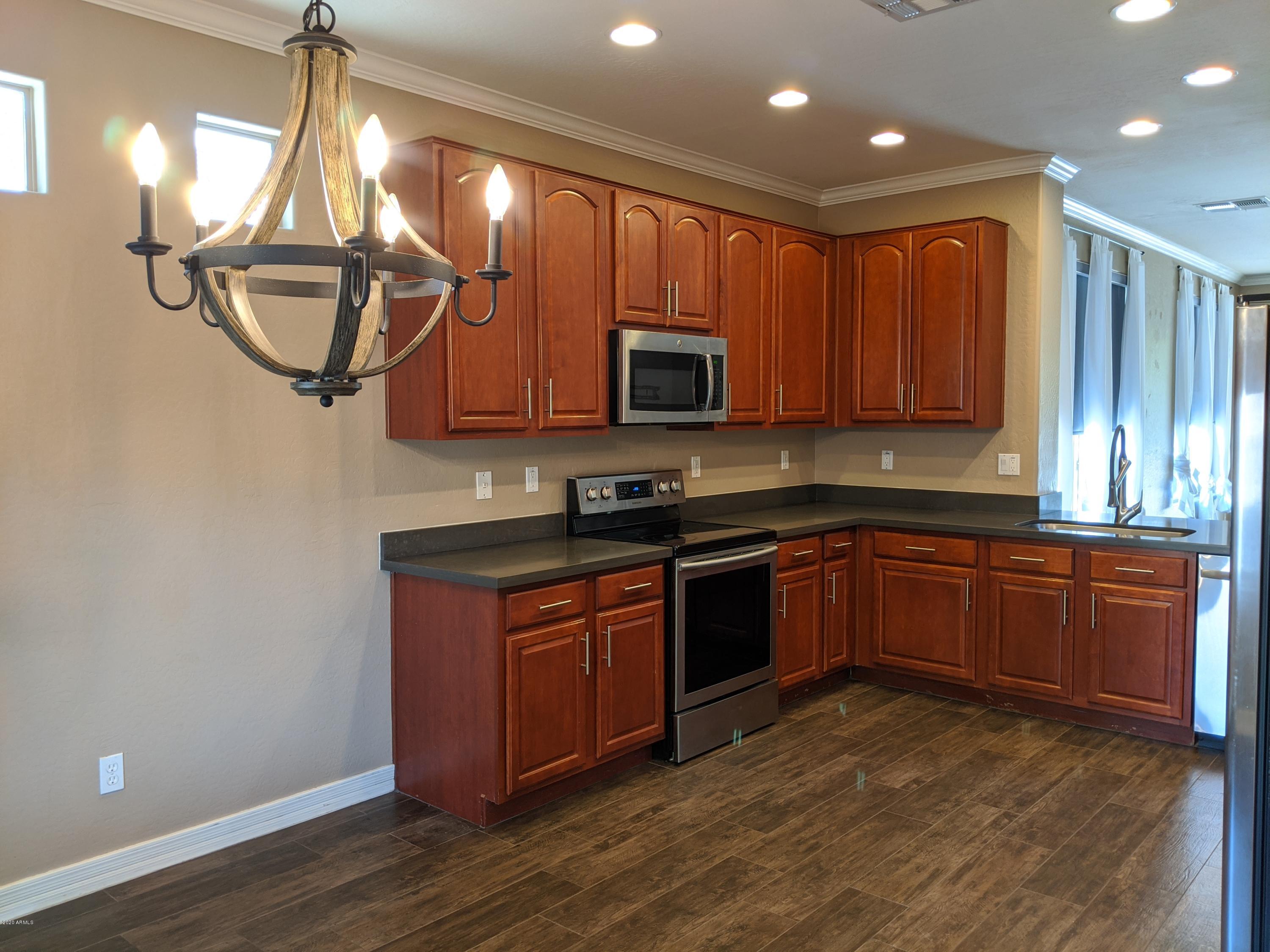 21019 East Avenida Del Valle Queen Creek, AZ 85142 - Photo 22 of 52 a kitchen with stainless steel appliances granite countertop a stove a sink dishwasher and a microwave oven with cabinets