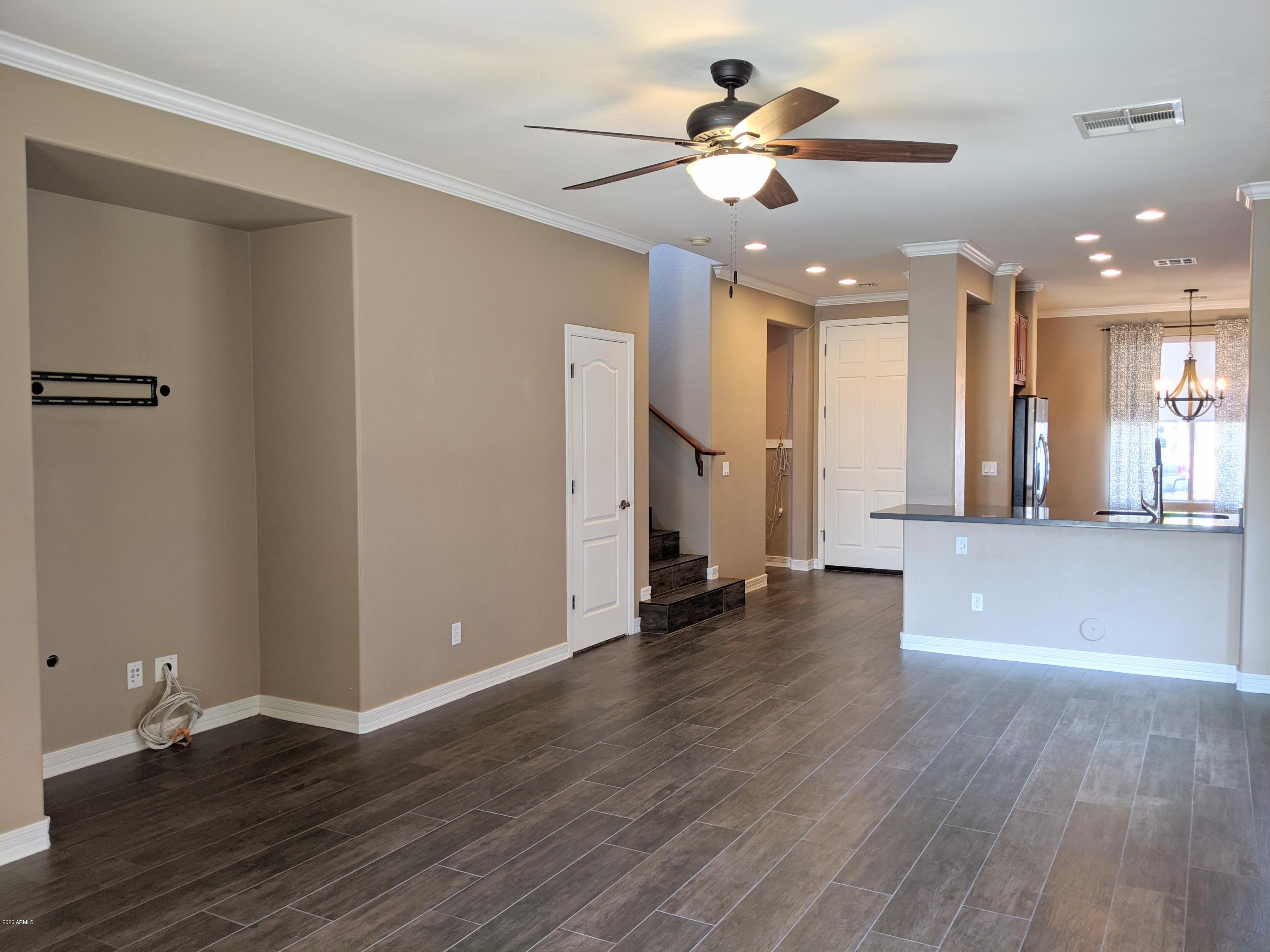 21019 East Avenida Del Valle Queen Creek, AZ 85142 - Photo 5 of 52 a view of an empty room with wooden floor and a ceiling fan