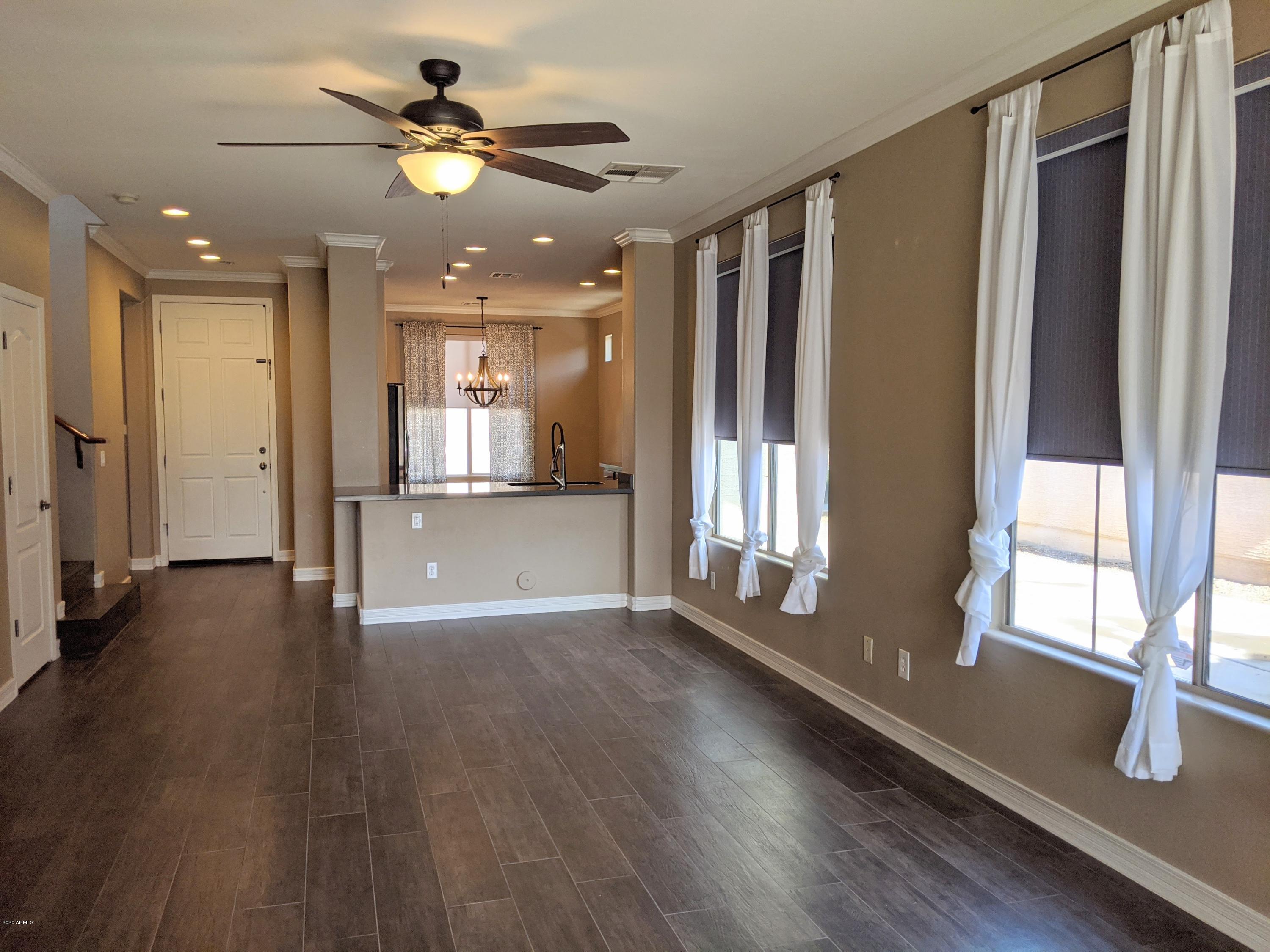 21019 East Avenida Del Valle Queen Creek, AZ 85142 - Photo 6 of 52 a view of an empty room and window with wooden floor