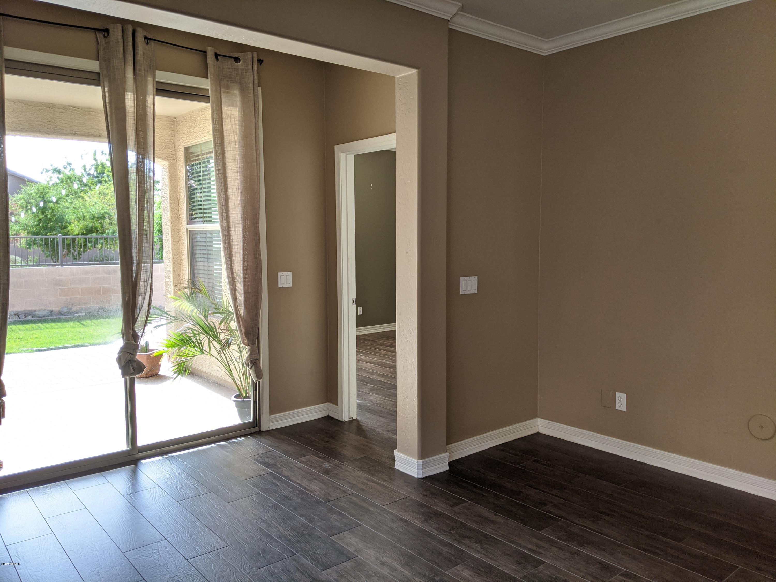21019 East Avenida Del Valle Queen Creek, AZ 85142 - Photo 8 of 52 a view of an empty room with wooden floor and a window