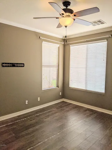 an empty room with a window and a fan