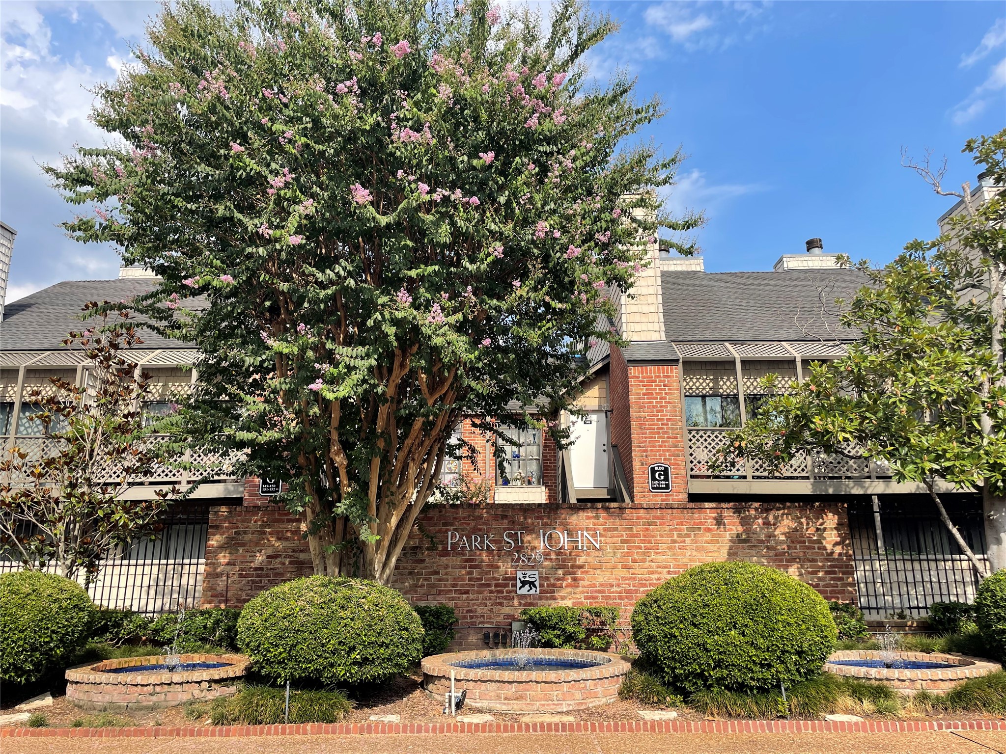 2829 Timmons Lane, Unit 215 Houston, TX 77027 - Photo 1 of 13 a front view of a house with garden