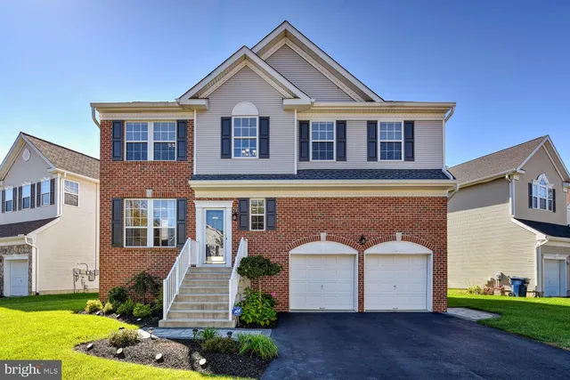 a front view of a house with a garden and plants