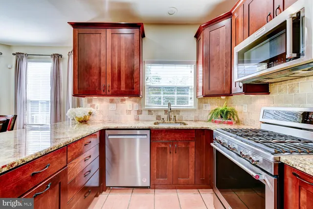 a kitchen with stainless steel appliances granite countertop a stove sink and cabinets
