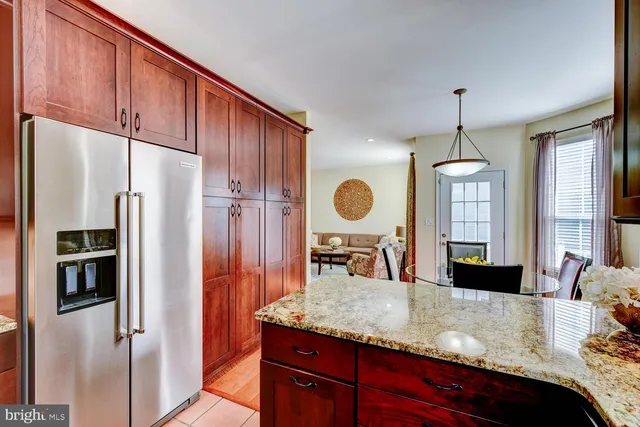a kitchen with stainless steel appliances granite countertop a refrigerator a stove and a sink with wooden floor