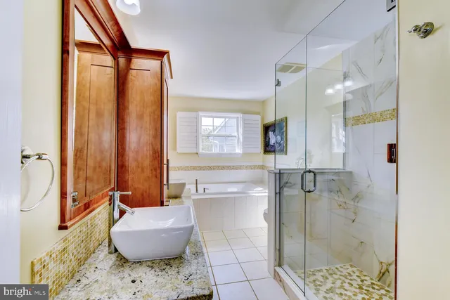 a bathroom with a granite countertop sink a toilet and shower