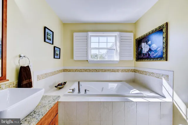 a bathroom with a tub sink and a window