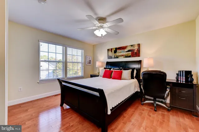 a bedroom with a bed a dresser and a large window
