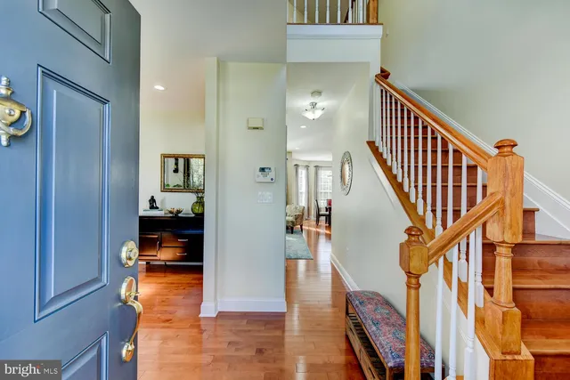 a view of a hallway with wooden floor and staircase