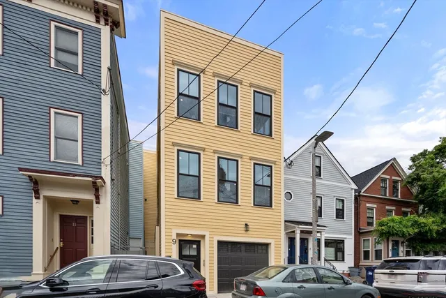 a front view of a building with lot of cars parked on road