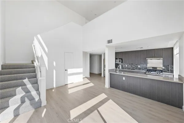 a kitchen with stainless steel appliances granite countertop a stove a sink and a refrigerator