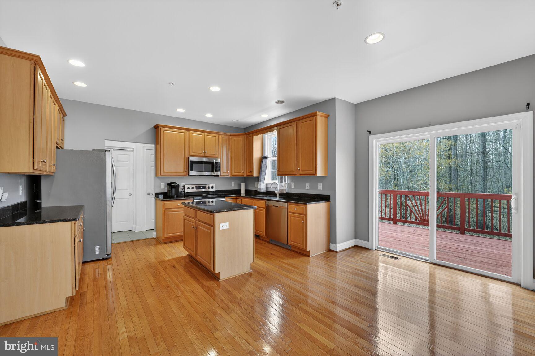 15900 Tanyard Road Upper Marlboro, MD 20772 - Photo 21 of 34 a kitchen with stainless steel appliances granite countertop a refrigerator a sink dishwasher a stove and white countertops with wooden floor