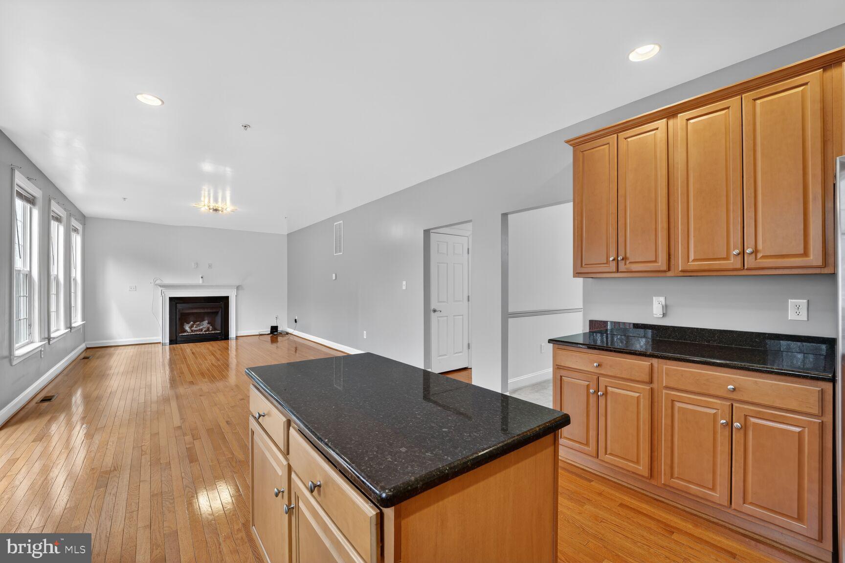 15900 Tanyard Road Upper Marlboro, MD 20772 - Photo 23 of 34 a kitchen with granite countertop a stove a sink dishwasher and a microwave with wooden floor
