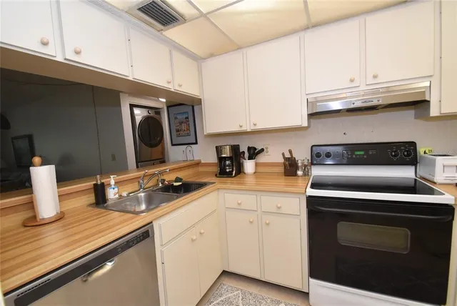 a kitchen with stainless steel appliances granite countertop a sink a stove and cabinets
