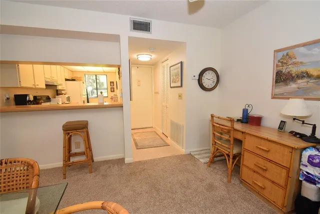 a view of a workspace with furniture and a window