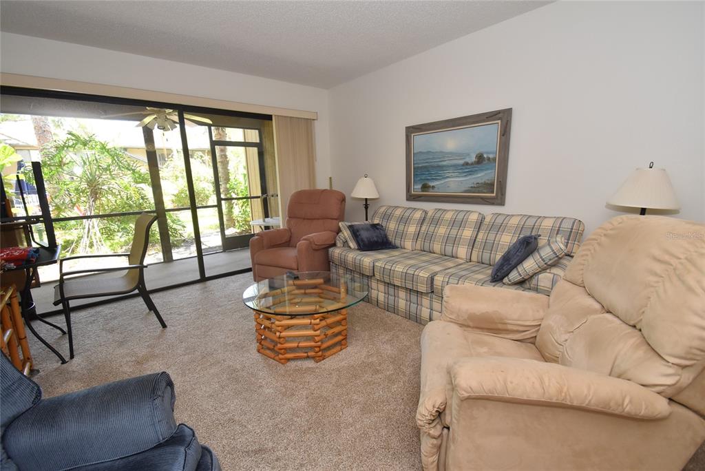 1709 Pelican Cove Road, Unit GL349 Sarasota, FL 34231 - Photo 6 of 29 a living room with furniture and floor to ceiling windows