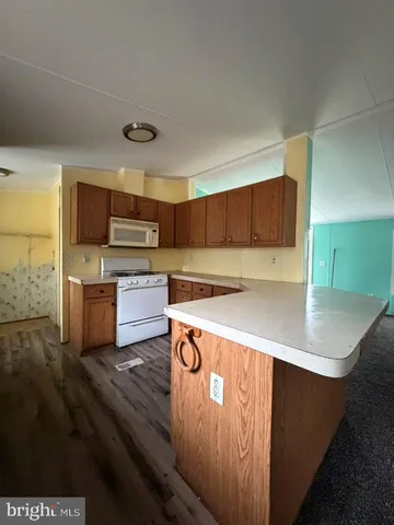 a view of kitchen and hall with wooden floor