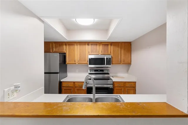a kitchen with stainless steel appliances a stove a sink and a microwave