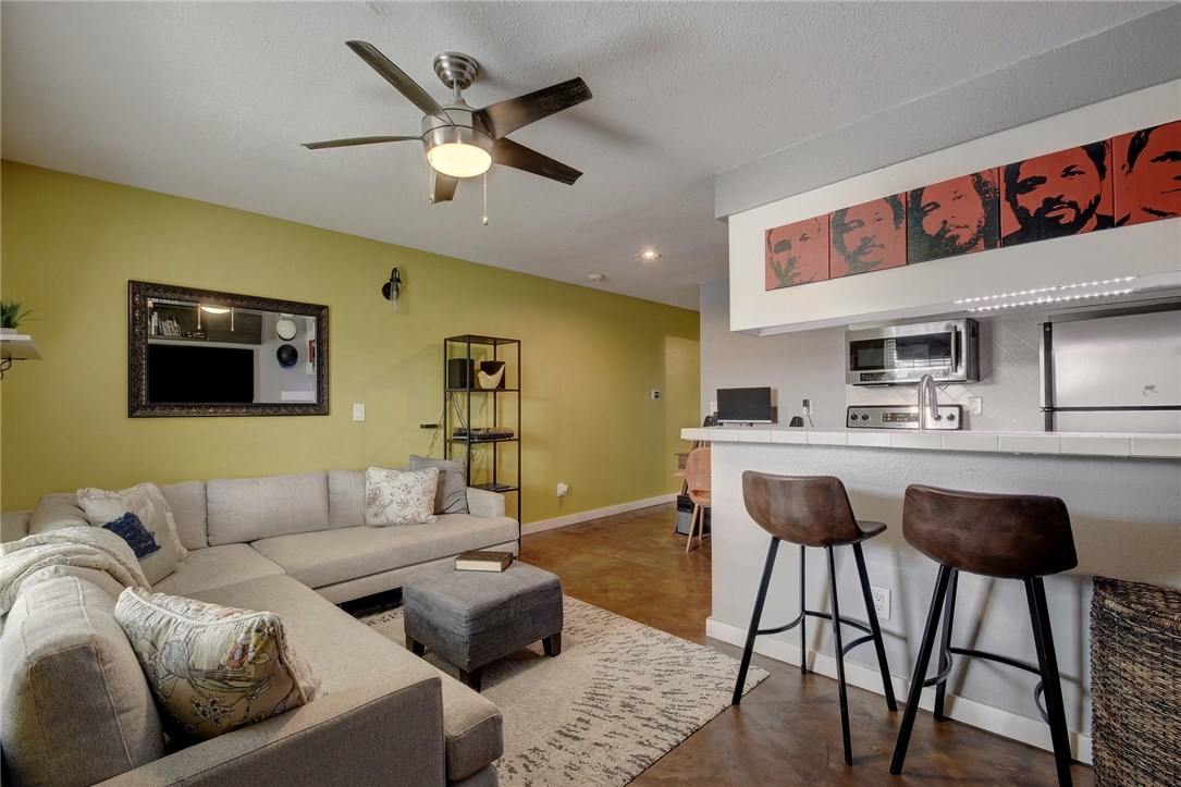 a living room with furniture kitchen view and a chandelier