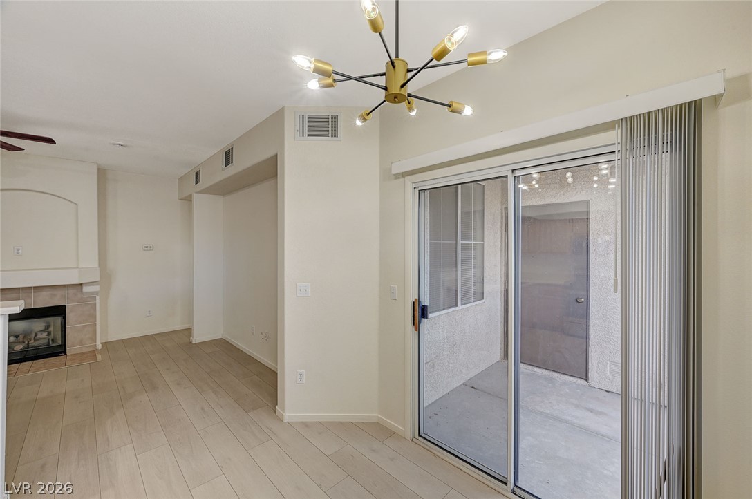 9050 West Warm Springs Road, Unit 1147 Las Vegas, NV 89148 - Photo 10 of 36 Luminous living area features wide plank flooring and a stylish modern chandelier.