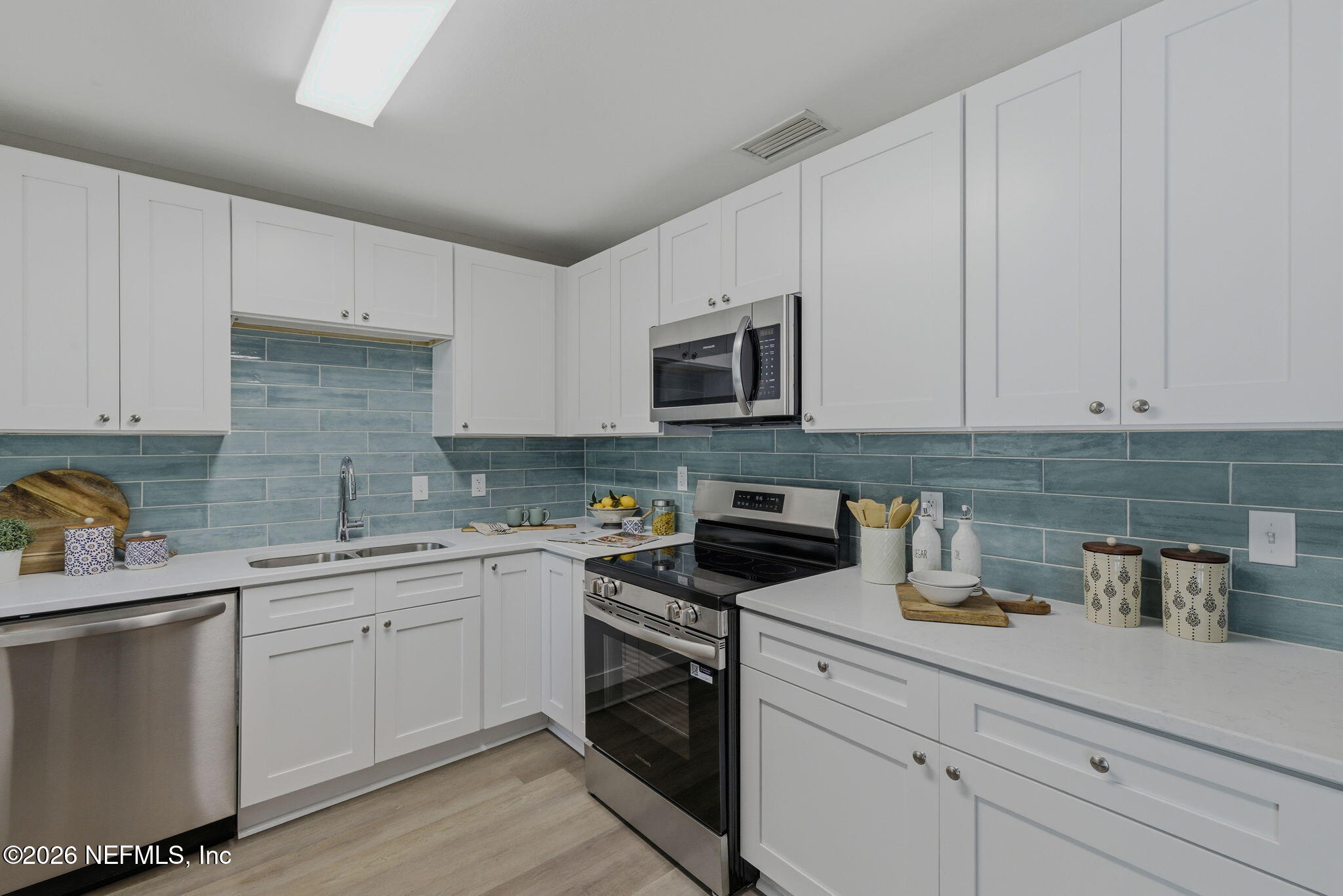10184 Herndon Road Jacksonville, FL 32246 - Photo 14 of 28 a kitchen with white cabinets stainless steel appliances and sink