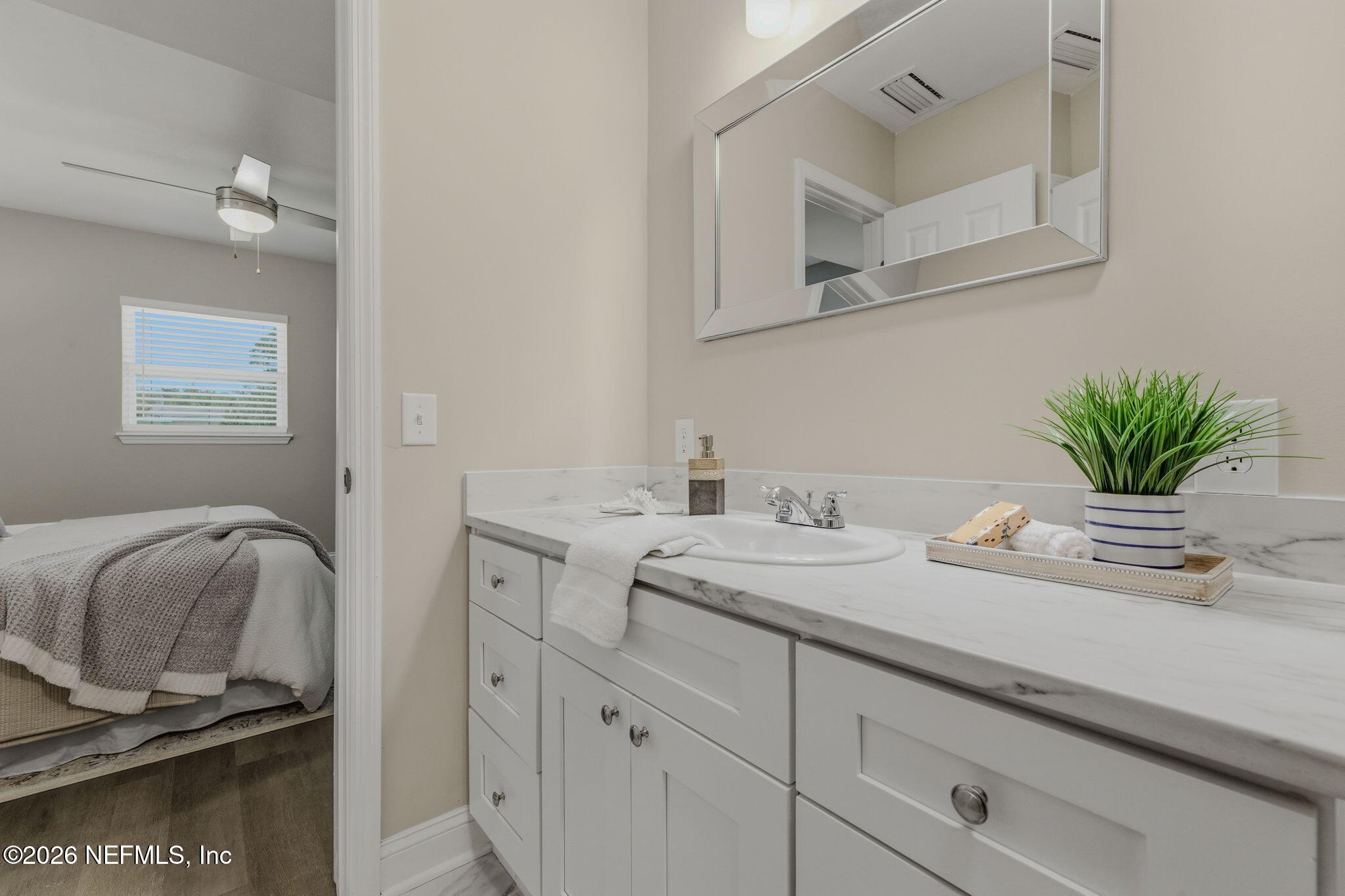 10184 Herndon Road Jacksonville, FL 32246 - Photo 23 of 28 a bathroom with a granite countertop sink a mirror and cabinets