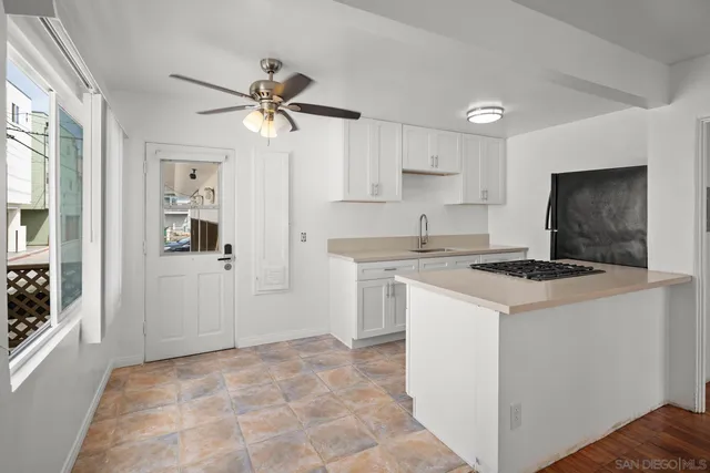 a view of a kitchen with wooden floor a sink and cabinet