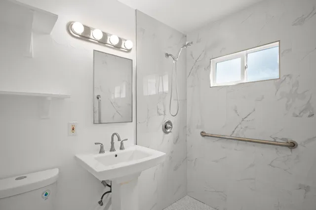 a living room with stainless steel appliances furniture a rug and a view of kitchen