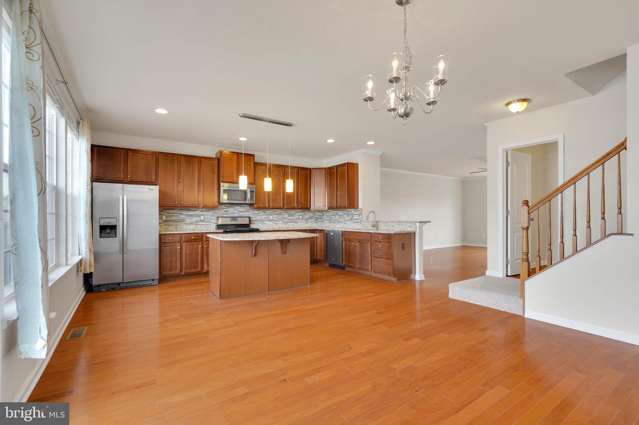 6 Lamplighter Lane Stafford, VA 22554 - Photo 5 of 37 a large kitchen with stainless steel appliances kitchen island granite countertop a table and chairs in it