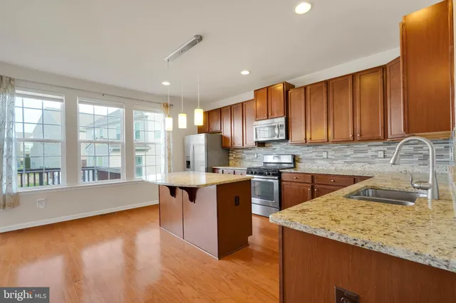 a kitchen with stainless steel appliances granite countertop a sink and a stove