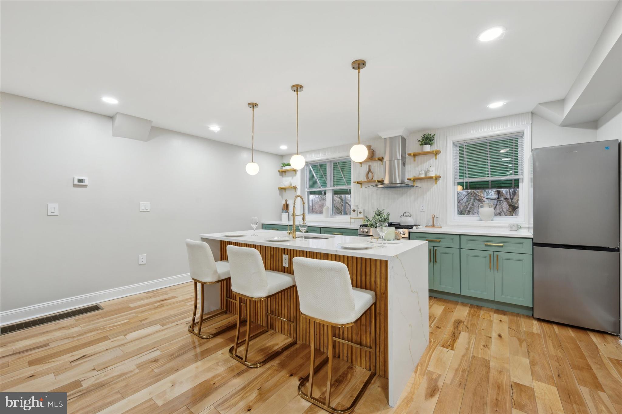 7533 Wheeler Street Philadelphia, PA 19153 - Photo 14 of 50 a kitchen with stainless steel appliances granite countertop a sink a stove a refrigerator and island with wooden floor