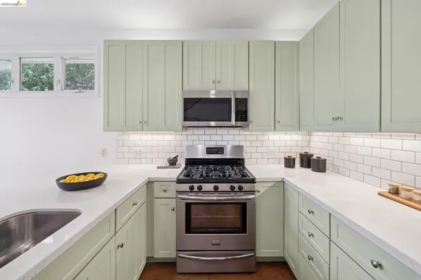a kitchen with stainless steel appliances a stove a sink a microwave and cabinets